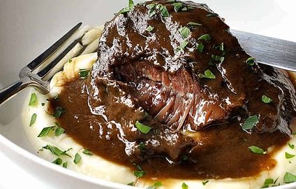 Slow cooked beef cheeks in red wine sauce on creamy mashed potato